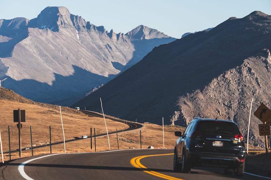 A car driving on a winding mountain road in Estes Park, Colorado