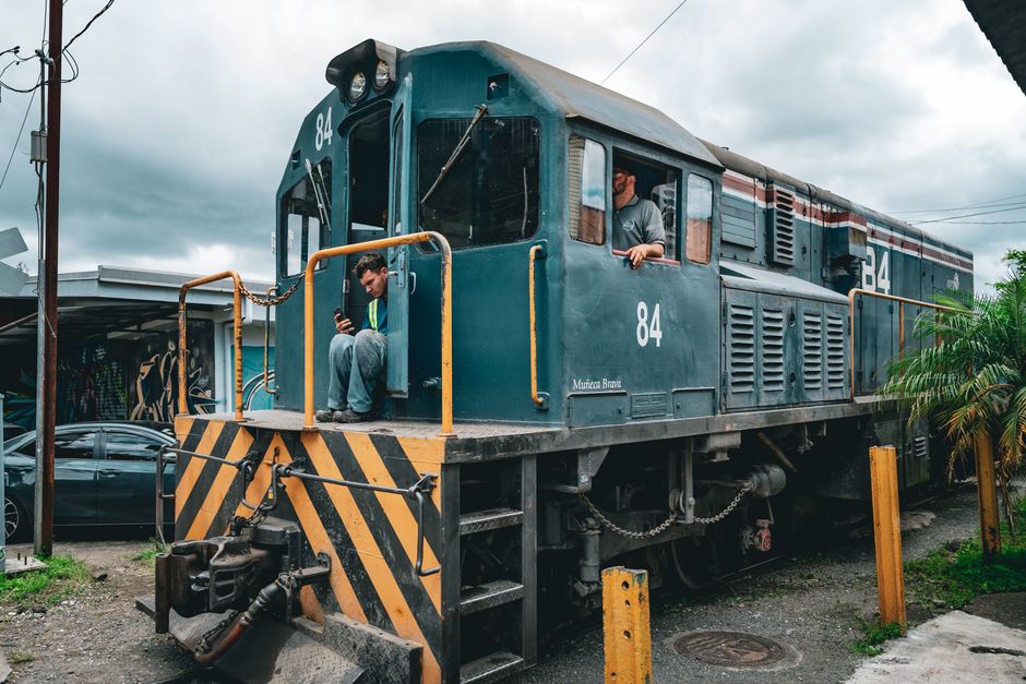 A vibrant street scene with a train conductor in San José, Costa Rica.