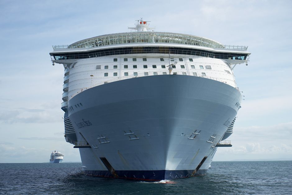 Front view of a luxury cruise ship navigating the sea under a clear sky.