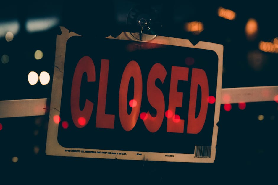 Moody image of a closed sign with bokeh lights, conveying nighttime closure.