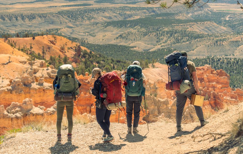 Backpackers at a scenic overlook in Bryce Canyon, Utah, enjoying stunning desert vistas.