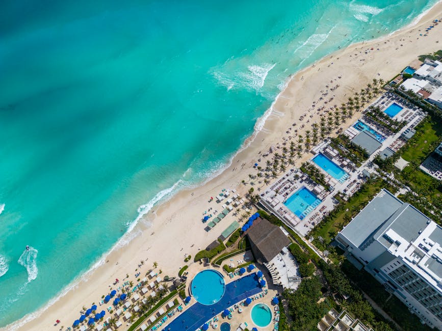 Stunning top view of a Cancun beach resort with turquoise water and sandy shore.