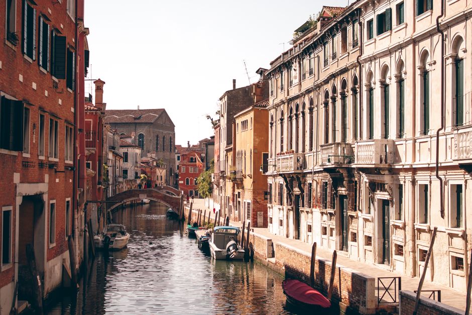 Explore a picturesque Venetian canal flanked by historic buildings, showcasing the charm of Italy's Renaissance architecture.