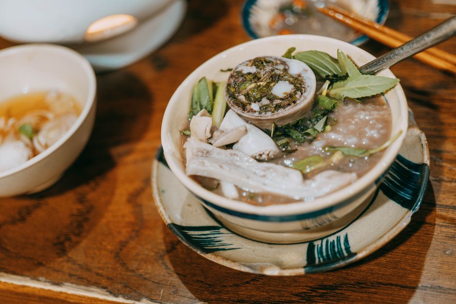 Traditional Vietnamese soup beautifully presented in a ceramic bowl, featuring herbs and spices.